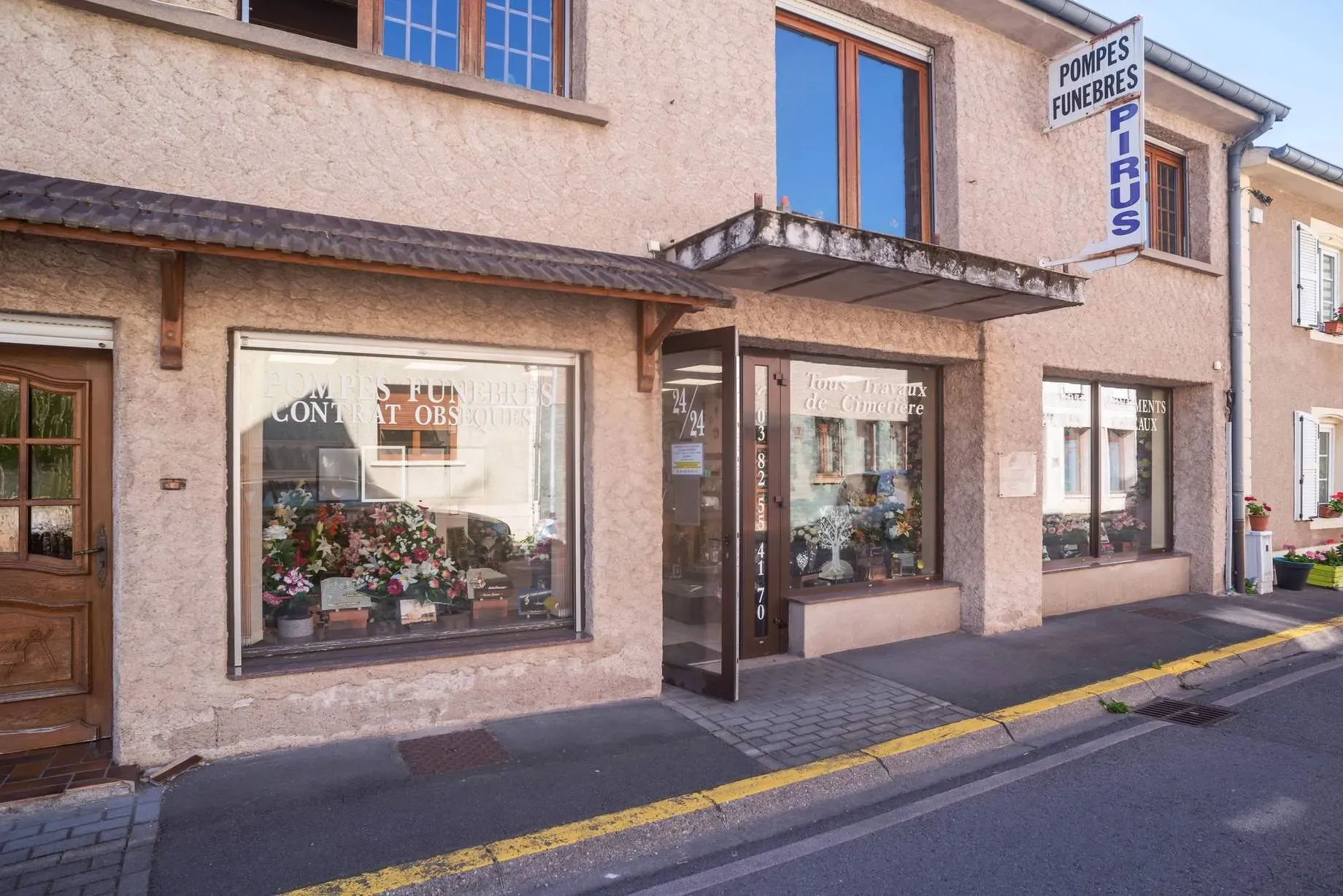 Devanture du magasin de pompes funèbres et marbrerie Pirus avec vitrines.