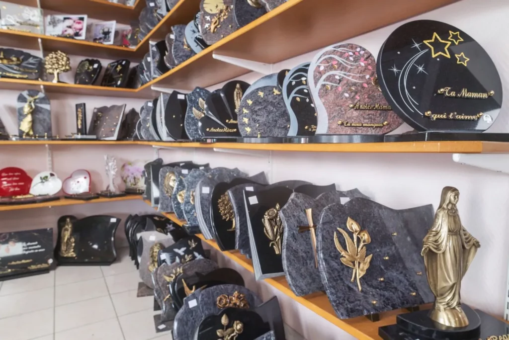 Modèles de plaques funéraires gravées exposés dans une boutique.