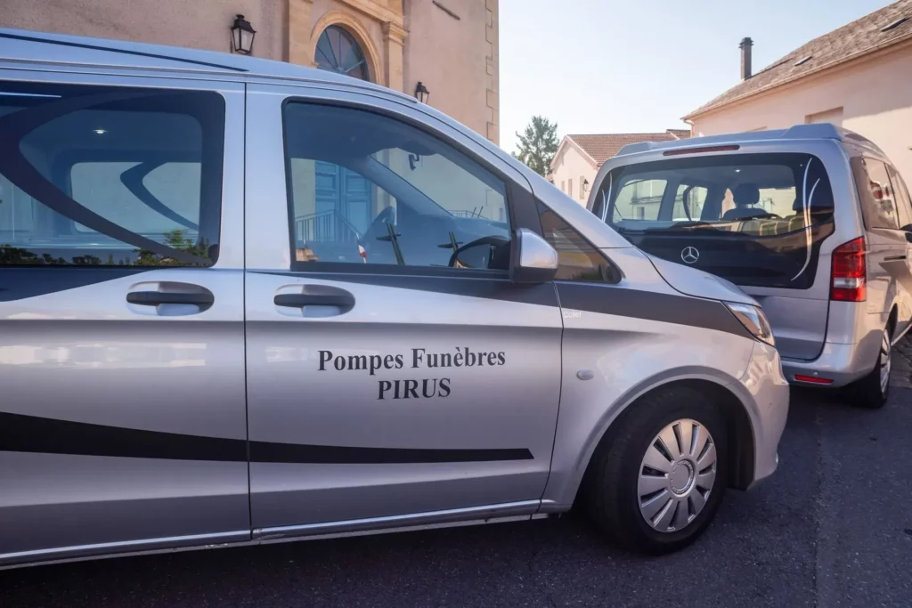 Véhicule de pompes funèbres argenté de marque Mercedes avec inscription PIRUS.
