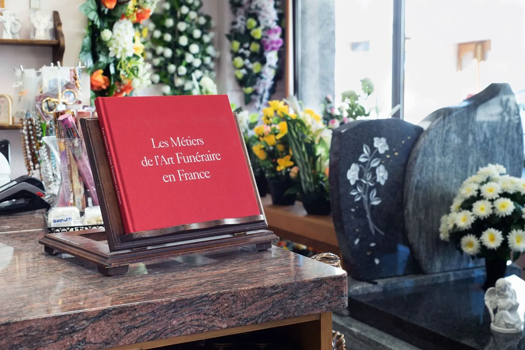 Livre sur les métiers de l'art funéraire posé sur un pupitre en bois.