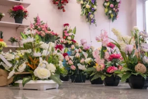 Pots de fleurs artificielles colorées pour funérailles exposés au sol.