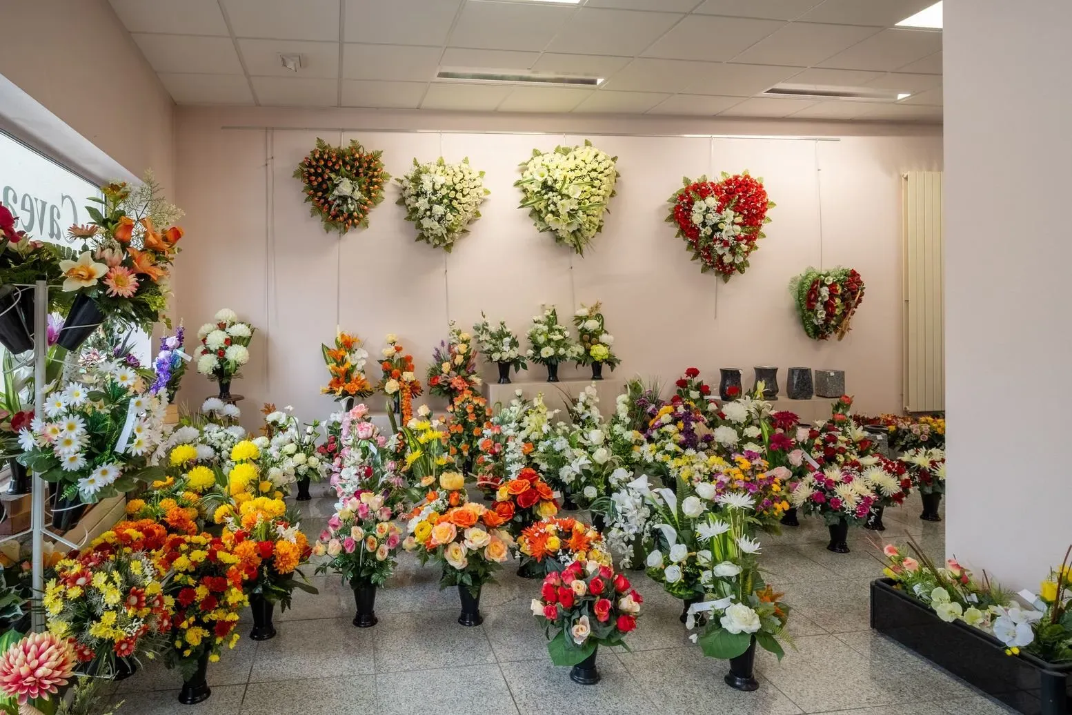Magasin d'articles funéraires avec bouquets de fleurs et courœurs murales.